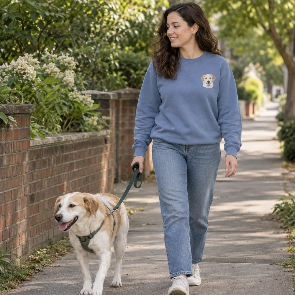 A dog owner wearing a sweatshirt with a small pet portrait on a walk